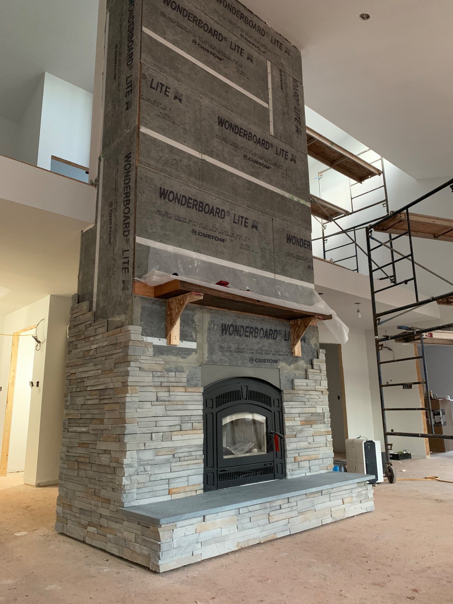 Thin manufactured stone veneer being installed over a prepared wall assembly