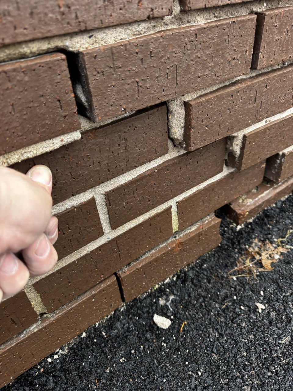 Open mortar joints and loose brick requiring assessment before repointing