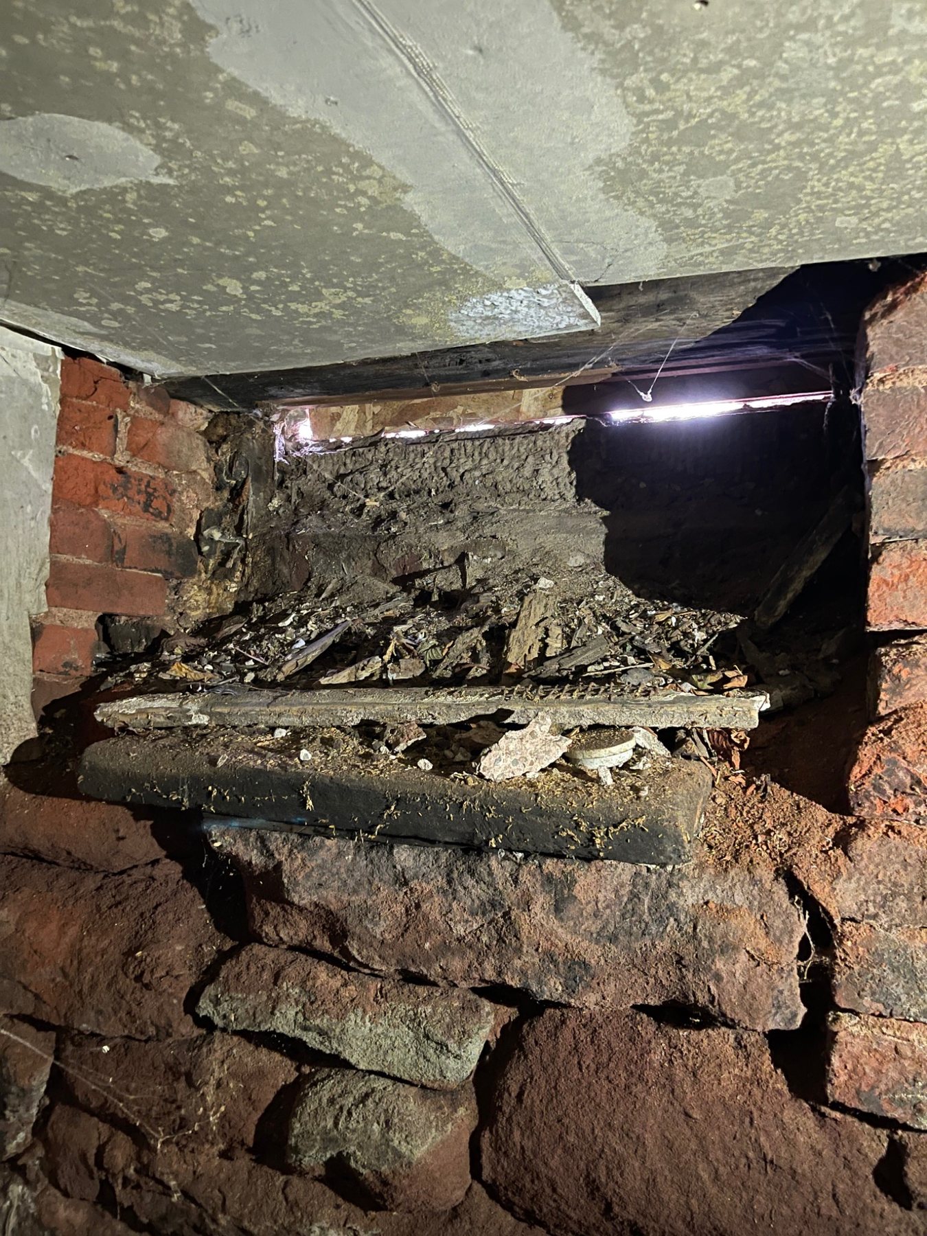 Older stone foundation with voids and mortar deterioration behind the visible surface