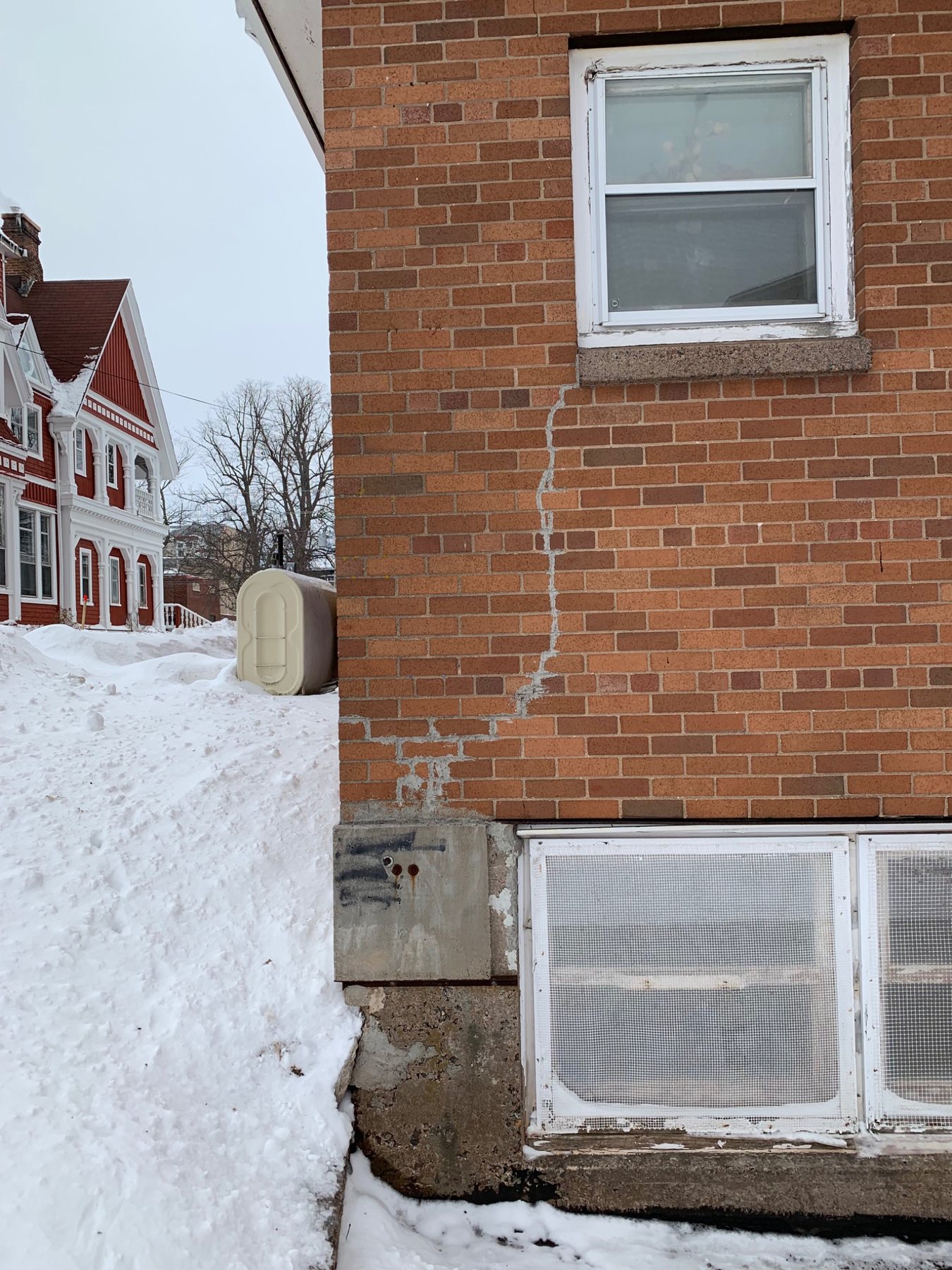 Brick masonry crack beside a window opening